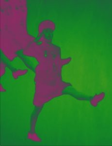 A person in a uniform and hat performs a high step with one leg raised, against a green background. Another partial figure echoes the same pose in the upper left corner. The A.P. ASTRA - Cross piece features a pink and green color scheme.