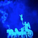A.P. ASTRA - Cross: A blue-tinted image of a statue featuring a winged figure riding a chariot pulled by four horses, with swirling mist or smoke in the background.